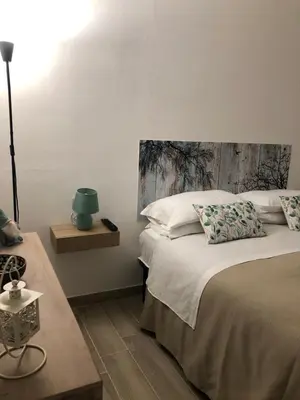 a bedroom with a large bed with a wooden headboard at Le Antiche Alcove in Terrasini