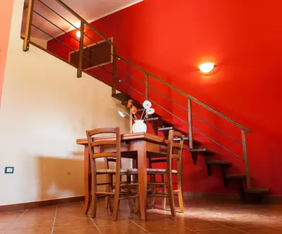 a dining room with a table and a red wall at Case Vacanza Longo in Balestrate