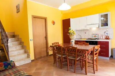 a kitchen and dining room with a table and chairs at Case Vacanza Longo in Balestrate