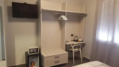 a bedroom with a bed and a desk in a room at Alma Hotel in Palermo