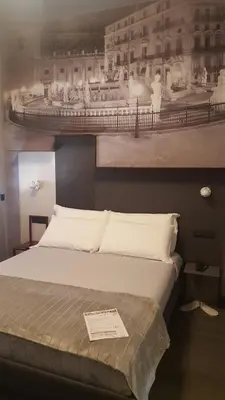 a bedroom with a bed with a picture on the wall at Alma Hotel in Palermo