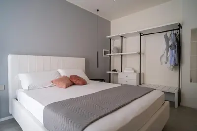 a bedroom with a white bed with two pillows on it at Acquamarina Rooms in Castellammare del Golfo