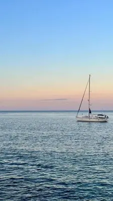 a sail boat in the middle of the ocean at The White Lodge in Porticello