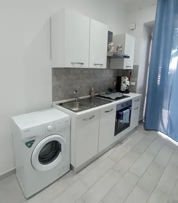 a kitchen with a washing machine and a sink at Sicilia House bluchic in Isola delle Femmine