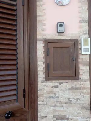 a wooden door in front of a brick wall at Sicilia House bluchic in Isola delle Femmine