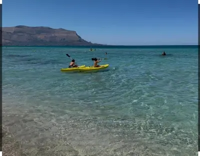 two people in a yellow kayak in the ocean at Sicilia House bluchic in Isola delle Femmine