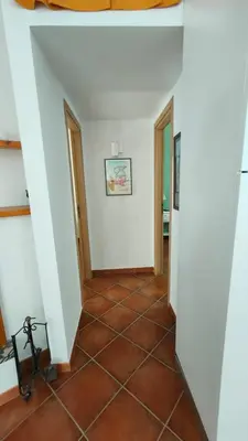a hallway with white walls and a tiled floor at Villa Calici in Pioppo