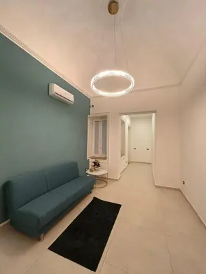 a living room with a blue couch and a table at margot palermo in Palermo