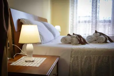 a bedroom with a bed with a lamp on a table at Sunshine Apartments in Trappeto