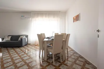 a dining room with a table and chairs and a couch at CAMA Casa Vacanze - Qui vivi la vera storia normanna in Palermo