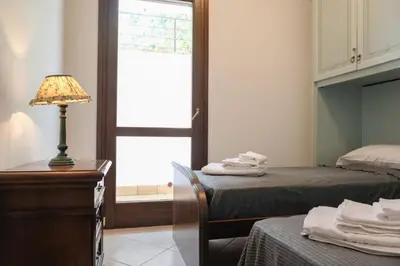 a bedroom with two beds and a lamp and a window at Grande Villa con Giardino e BBQ vicino al Mare in Mondello