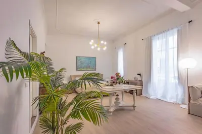 a living room with a table and a plant at Kepos Rooms and Suites in Palermo