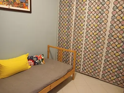 a room with a bed and a wall with a curtain at Mondello La Piazzetta Apartment in Palermo