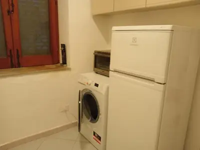 a kitchen with a refrigerator and a washing machine at Mondello La Piazzetta Apartment in Palermo