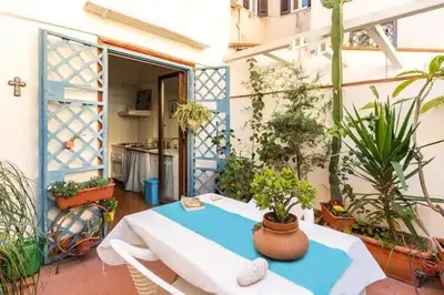 a patio with a table and some potted plants at At Kalsa Quiet Flowered Terrace! Free Parking! Ideal for remote working! in Palermo