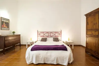 a bedroom with a large bed and two tables at At Kalsa Quiet Flowered Terrace! Free Parking! Ideal for remote working! in Palermo