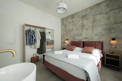 a bedroom with a large bed and a bath tub at Villa Charme in San Vito lo Capo