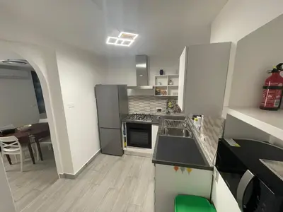 a kitchen with stainless steel appliances and a table at Mondello - La casa del vecchio pescatore in Palermo