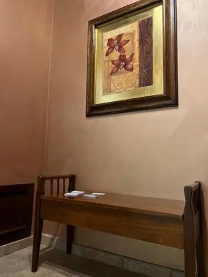 a painting hanging on a wall next to a wooden bench at Bacio del sole Apartment in Palermo