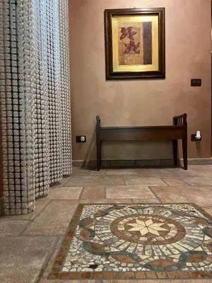 a room with a bench and a mosaic tile floor at Bacio del sole Apartment in Palermo
