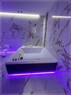 a white bathroom with a tub with purple lighting at ARIOSTO HOME in Palermo