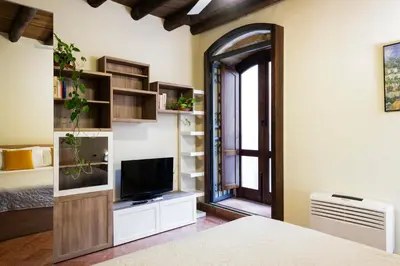 a bedroom with a bed and a tv and a mirror at I Carrettieri - a few steps from the Cathedral in Palermo