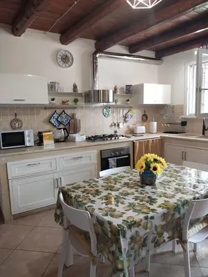 a kitchen with a table with a floral table cloth at Casetta Matotta, casa vacanze a Mondello - Palermo in Mondello