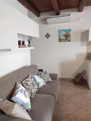 a living room with a couch with pillows on it at Casetta Matotta, casa vacanze a Mondello - Palermo in Mondello