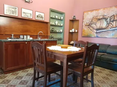 a dining room with a table and a sink at Casa Castelli Appartamento vacanza in Bagheria