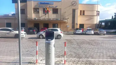 a parking meter in front of a building with parked cars at La Terrazza Solarium, in pieno centro 60m dalla stazione ferroviaria 700m dal mare in Santa Flavia