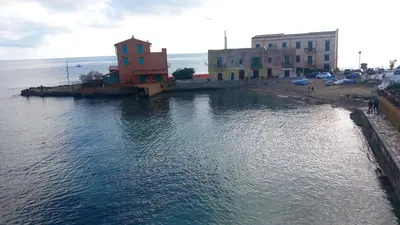 a metal fence next to a beach with the water at La Terrazza Solarium, in pieno centro 60m dalla stazione ferroviaria 700m dal mare in Santa Flavia
