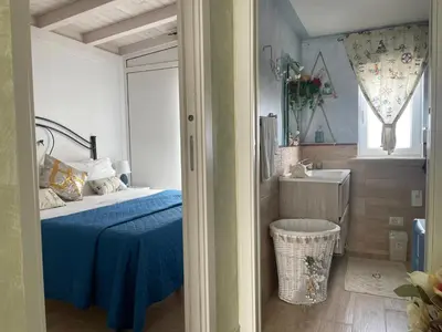 a bedroom with a blue bed and a sink at La Terrazza Solarium, in pieno centro 60m dalla stazione ferroviaria 700m dal mare in Santa Flavia