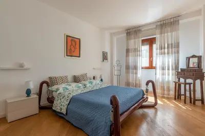 a bedroom with a bed and a table and a chair at La Cassatella family home in Palermo