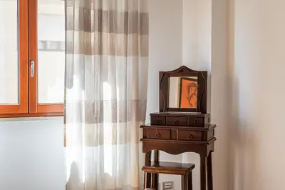a mirror on a dresser next to a window at La Cassatella family home in Palermo