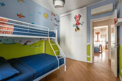 a bedroom with a bunk bed with mickey mouse wallpaper at La Cassatella family home in Palermo