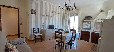 a kitchen and living room with a table and chairs at Casetta Sferracavallo in Palermo