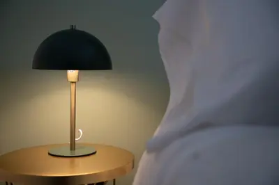 a lamp sitting on a table next to a bed at la porta di Alba in Palermo