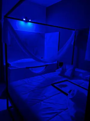 a dark room with a bed with a blue light at la porta di Alba in Palermo