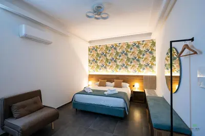 a hotel room with a bed and a chair at New River Hotel in Borgetto