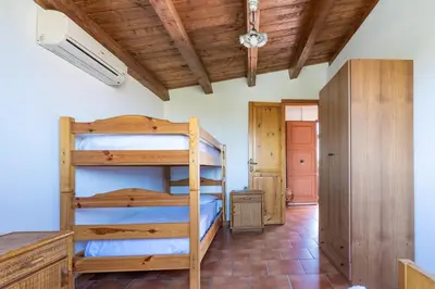 a bedroom with two bunk beds and a wooden ceiling at Casa Margherita Cefalù - Villa con accesso privato al mare in Cefalù