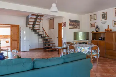 a living room with a blue couch and a table at Casa Margherita Cefalù - Villa con accesso privato al mare in Cefalù
