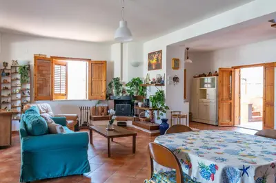 a living room with a blue couch and a table at Casa Margherita Cefalù - Villa con accesso privato al mare in Cefalù