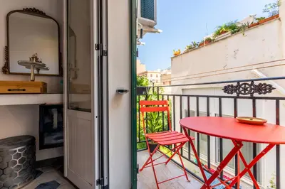 a red table and two chairs on a balcony at Regina Suite in Palermo