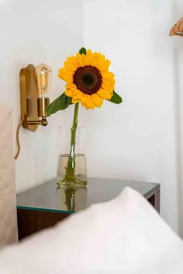a vase with a yellow flower on a table at Regina Suite in Palermo