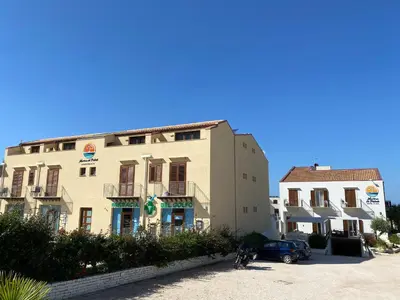 a building with a car parked in front of it at Marina di Petrolo Apartments in Castellammare del Golfo