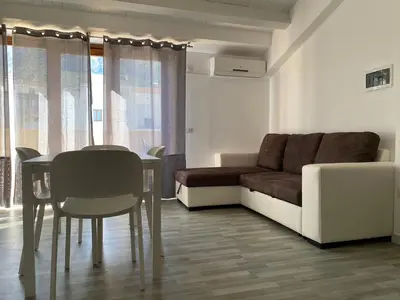 a living room with a table and a couch at Marina di Petrolo Apartments in Castellammare del Golfo
