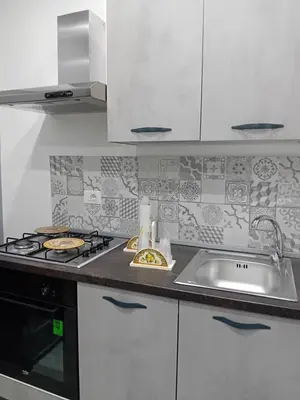 a white kitchen with a sink and a stove at Casa Mauro in Palermo