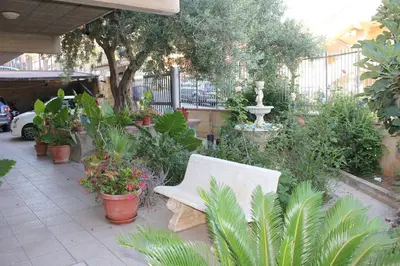 a white bench sitting in a garden with plants at B&B Ulivo in Trabia