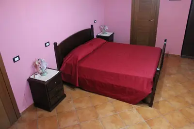 a bedroom with a red bed and two night stands at B&B Ulivo in Trabia
