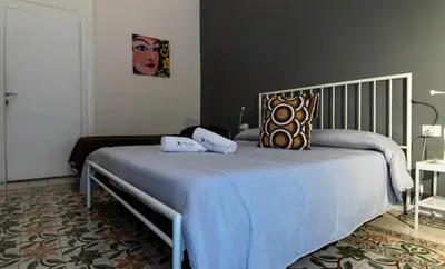 a bedroom with a large bed with blue sheets and pillows at C'era Una Volta in Palermo